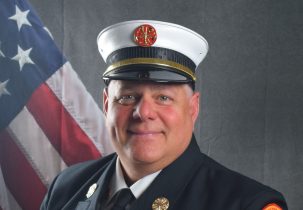 Portrait of David Cambareri in Class A uniform in front of American flag backdrop